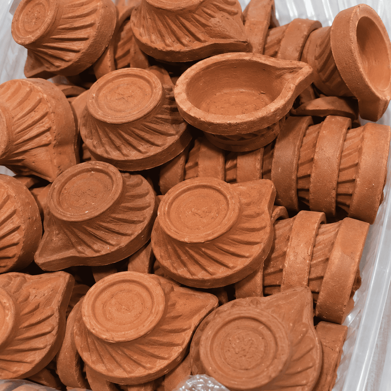 stacked terracotta diyas in a container (1) stacked terracotta diyas in a container (1)